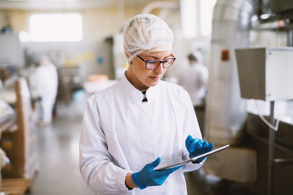 trabajadora realizando control de producto normas de calidad iso