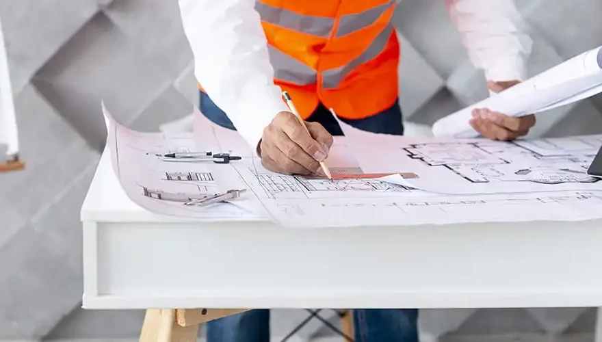 Chef de chantier regardant et crivant sur les plans de construction