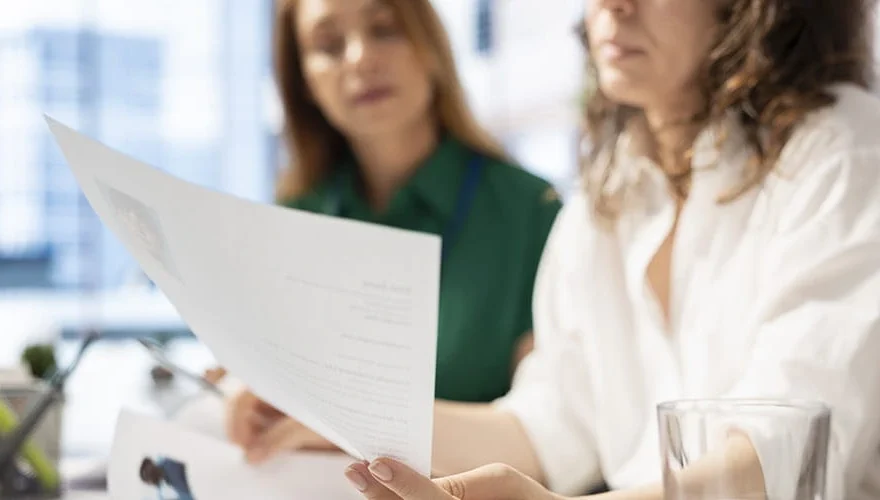 Responsable Ressources Humaines montrant un document une employe