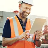 Homme travaillant dans le gros oeuvre avec une tablette  la main