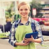 La merchandiser dans une jardinerie avec une tablette sous le bras