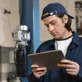 Suivi des quipements fait avec une tablette tactile par un homme