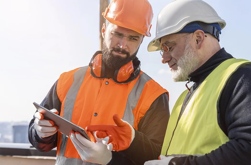Deux techniciens de maintenance regardant une tablette de travail