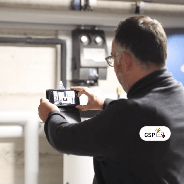 Philippe Ranc responsable romand du Groupement professionnel suisse pour les pompes chaleur GSP prenant en photo une pompe chaleur avec son tlphone sur lapplication Kizeo Forms